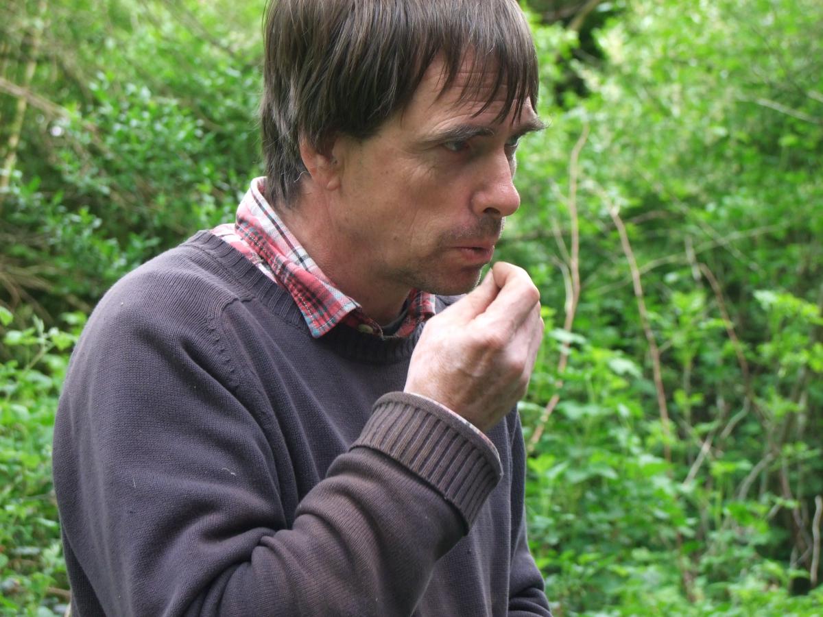 Martin Crawford goûte une fleur de sa forêt jardin - crédit Diana Semaska