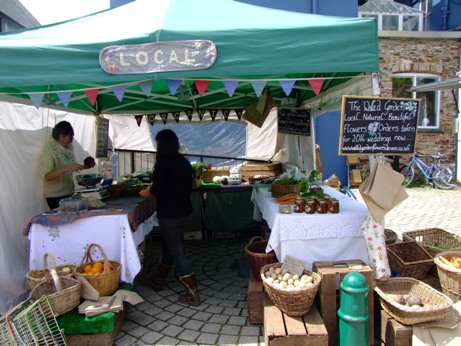 marchande de fruits, légumes et fleurs locaux sur le marché de Totnes